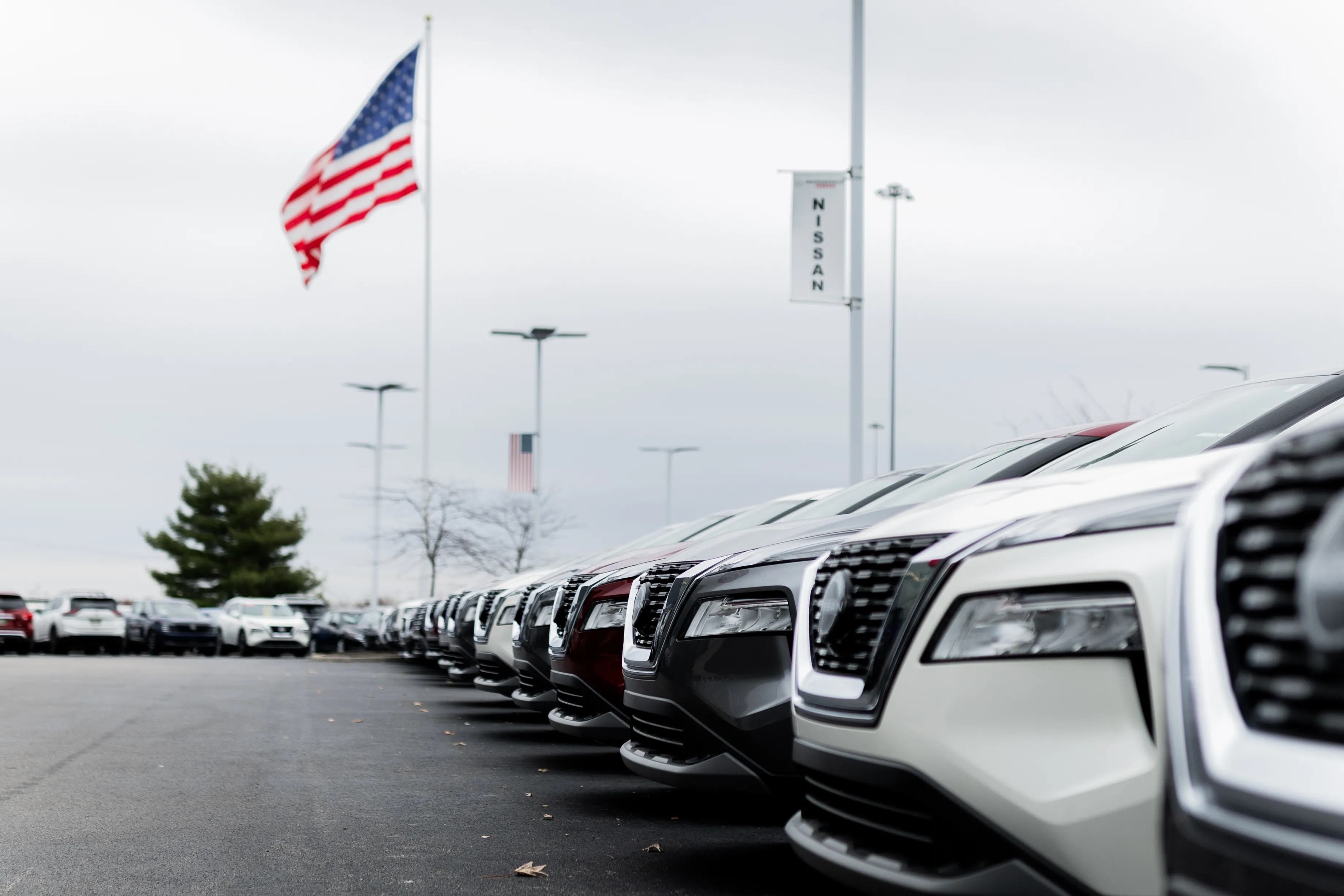 Rows of vehicles on the Georgesville lot beneath the American flag